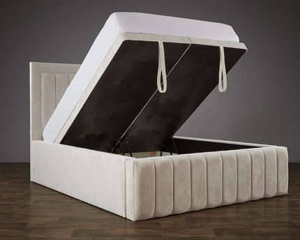 Divan ottoman bed with gas-lift storage open, showing spacious underbed compartment, upholstered in plush champagne velvet with panel headboard – RSB Furniture